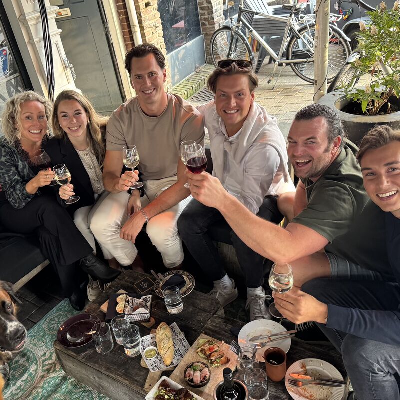 Tevreden klanten die samen proosten op een terras